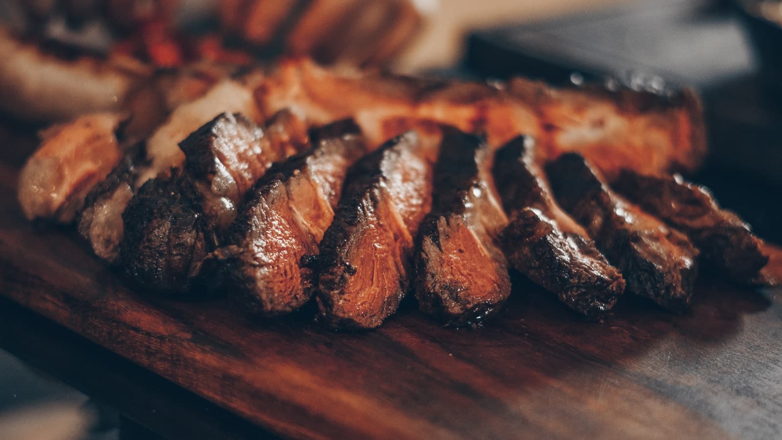 Chef grilling premium proteins on a hot flat-top grill